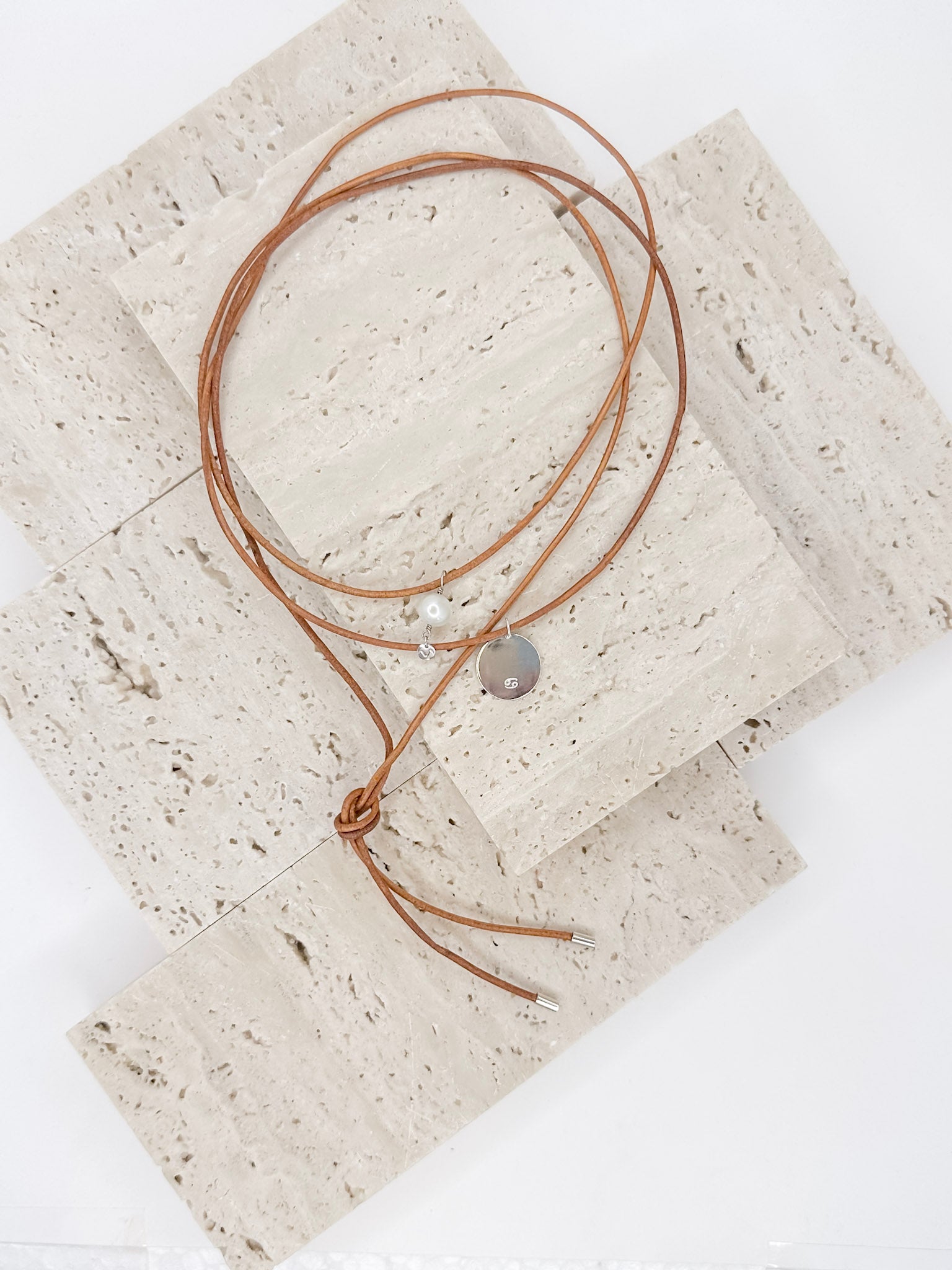 Colar em couro natural com três voltas e ponteiras em prata 925, um pingente com pérola natural de 8mm e uma medalha em prata com desenho dos signos personalizado.