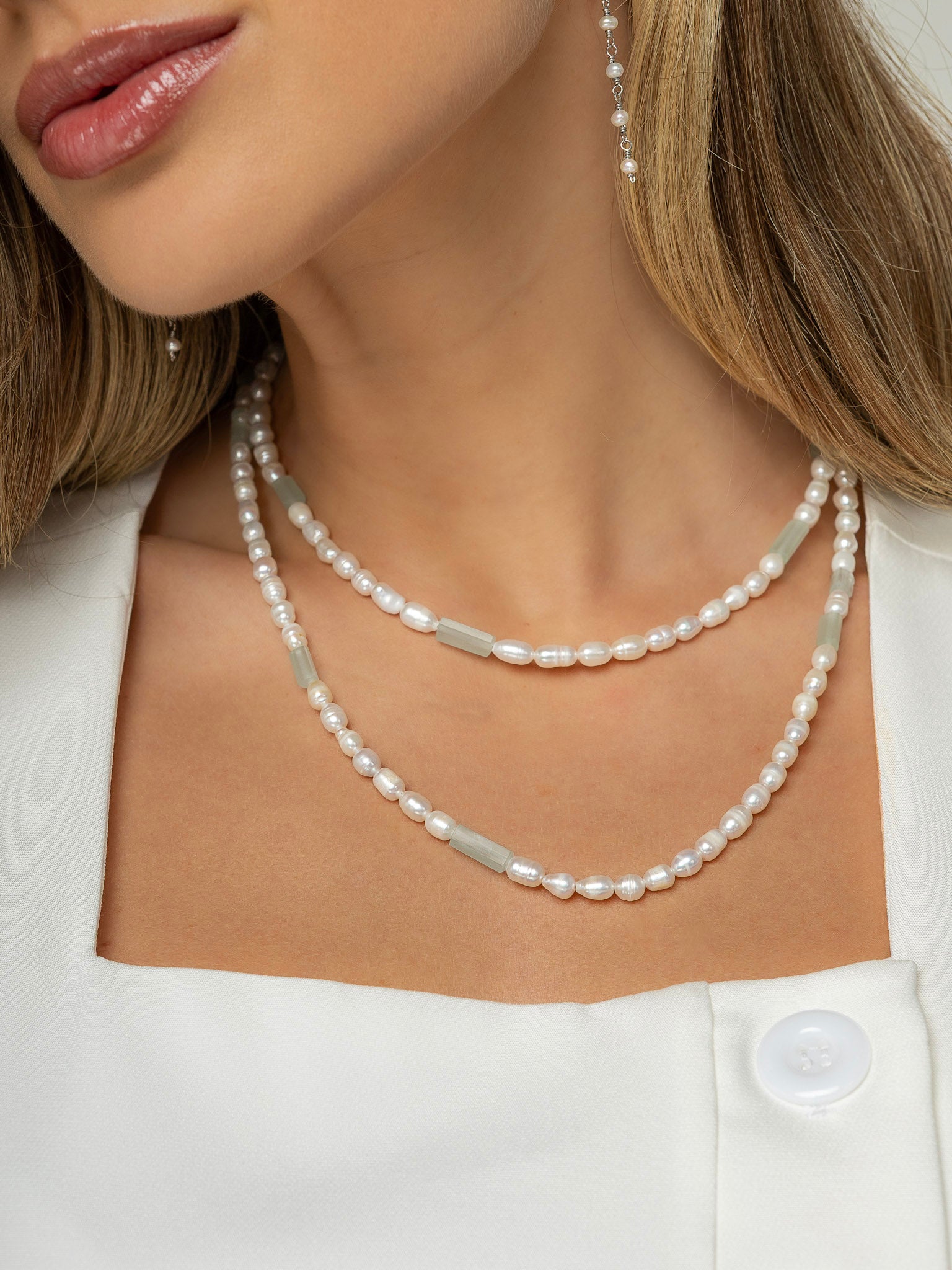 Mulher veste colar de perolas mescladas com águas marinhas naturais em formato de canudos, colar medindo 90 cm em duas voltas no pescoço.