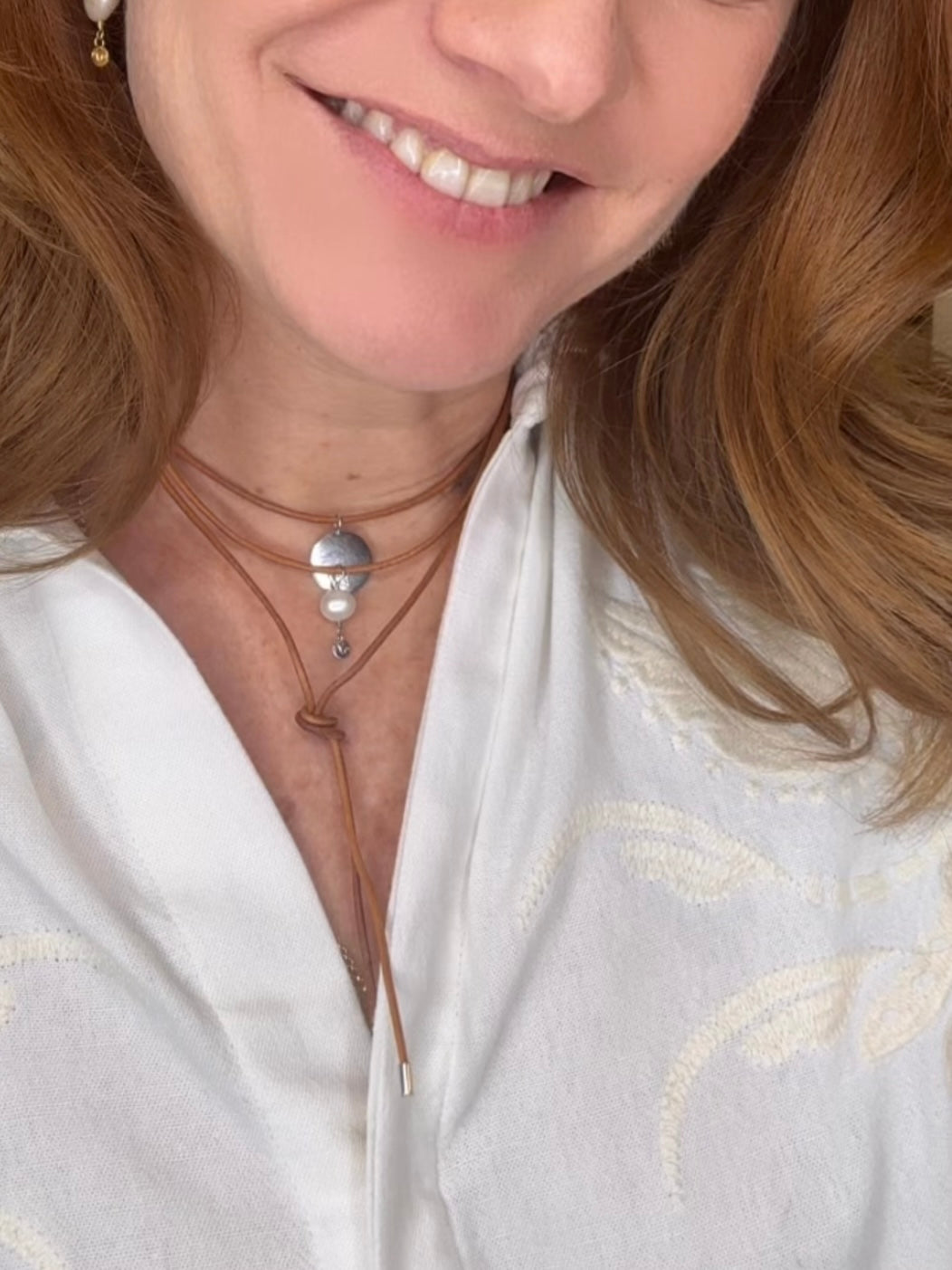 Colar em couro natural com três voltas e ponteiras em prata 925, um pingente com pérola natural de 8mm e uma medalha em prata com desenho dos signos personalizado.